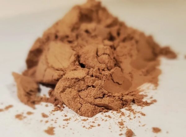 A pile of brown powder sitting on top of a white plate.
