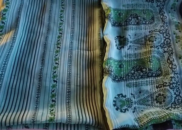 A close up of the fabric with some green and blue designs