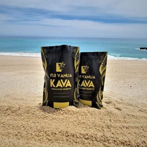 Two bags of coffee sitting on the beach.