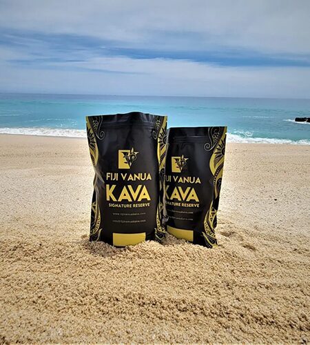 Two bags of coffee sitting on the beach.