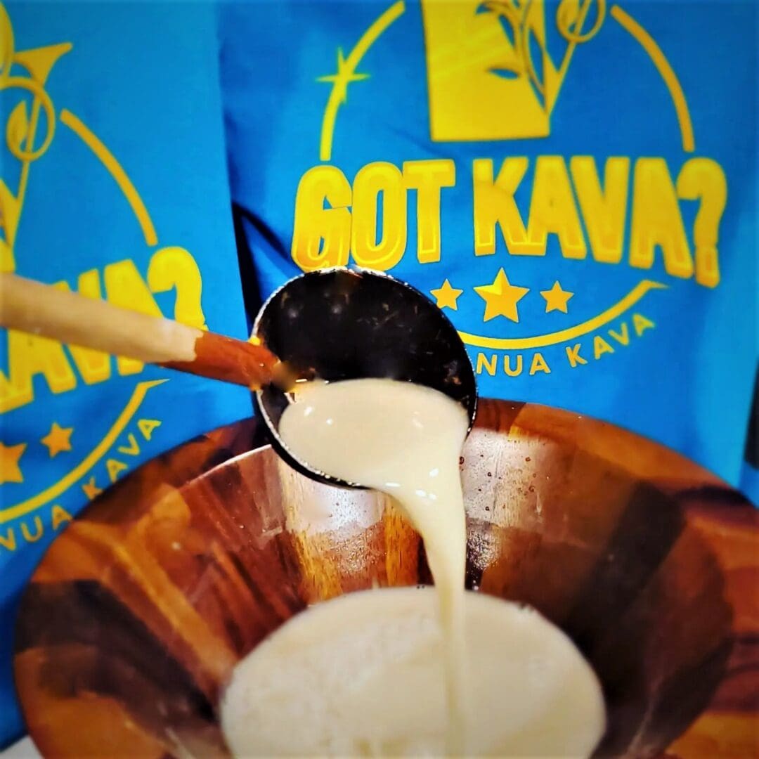 Kava being poured into a wooden bowl.