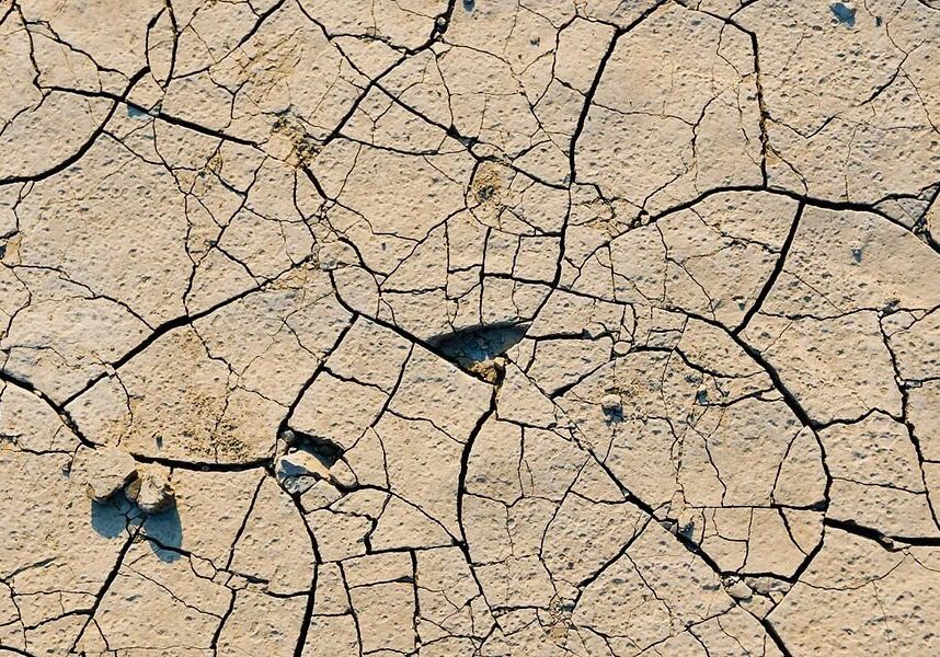 A close up of cracked earth with some dirt