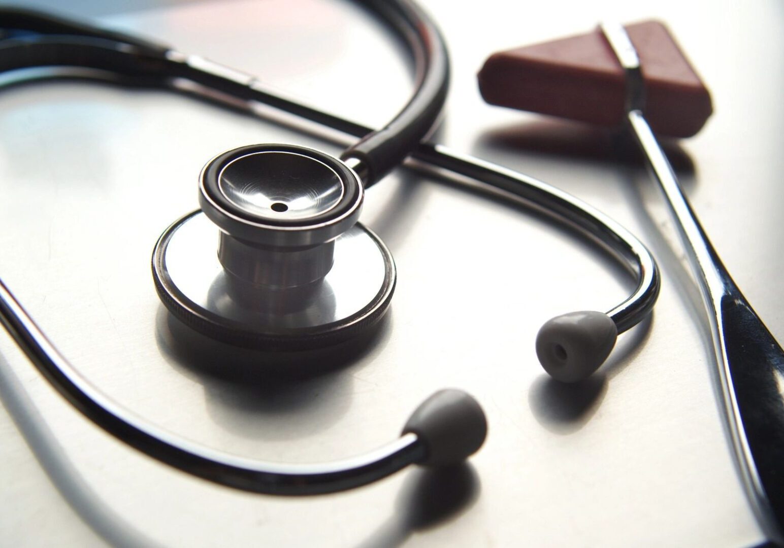 A stethoscope and ear buds on top of a table.